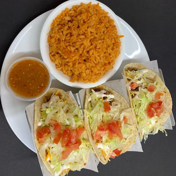 Three Marabella's Tacos with lettuce, tomato, and cheese, served with a side of rice and salsa.