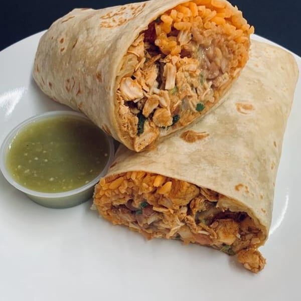 Two large Marabella's Tacos burritos, cut in half, revealing chicken and rice, with a side of green salsa.
